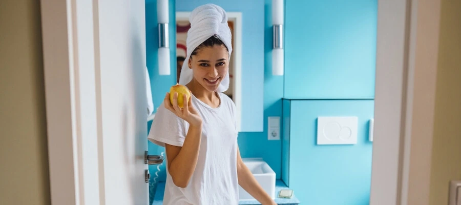 Mulher jovem no banheiro, segurando uma ma