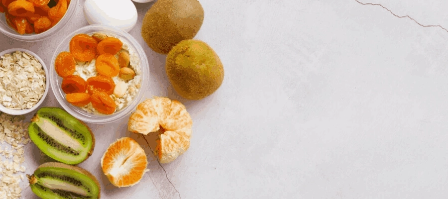 kiwi, laranja, tangerina ovos, iogurte e farelo de aveia sobre uma superf